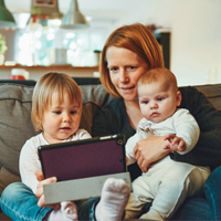 Mother working from home on sofa with child