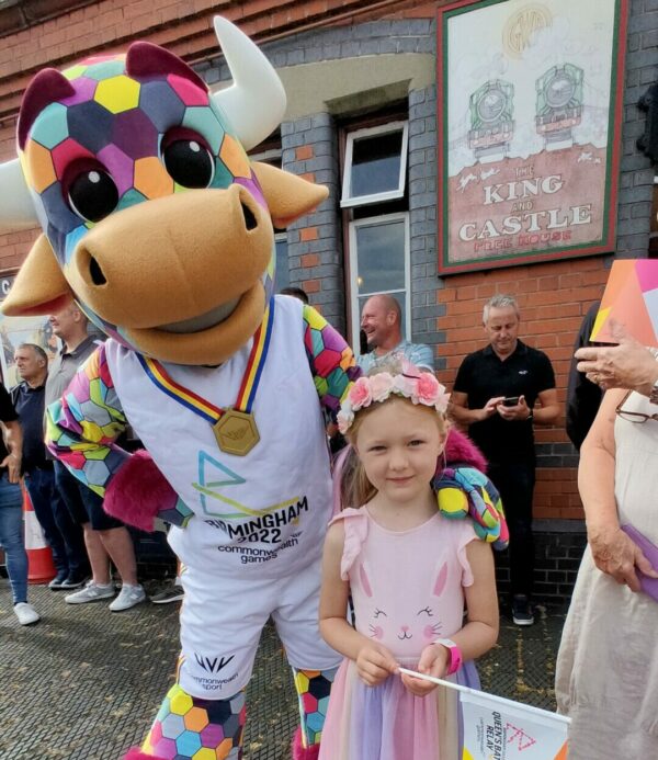 Perry the Birmingham 2022 Commonwealth Games mascot in pose with young girl