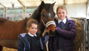 girls smiling with pony