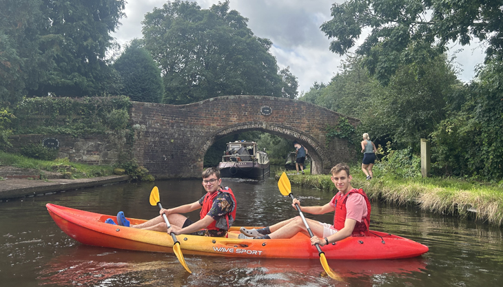 Two Boys Kayaking On A Canal In Kinver