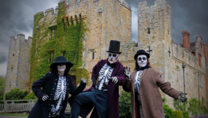hever Castle and gardens halloween with three adults dressed up as skeletons for a spooky spooktacular haunted halloween

