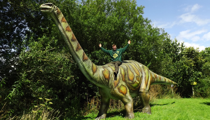 Man on a pretend dinosaur at Lower Drayton Farm