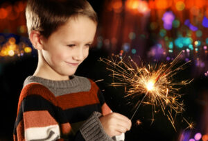 Fireworks night events in Surrey and West Sussex, young boy holding a sparkler