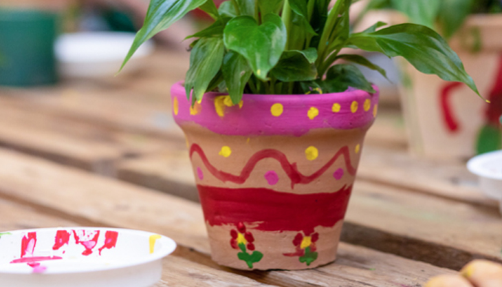 Flower Pot Painted By A Child, With A Plant In It