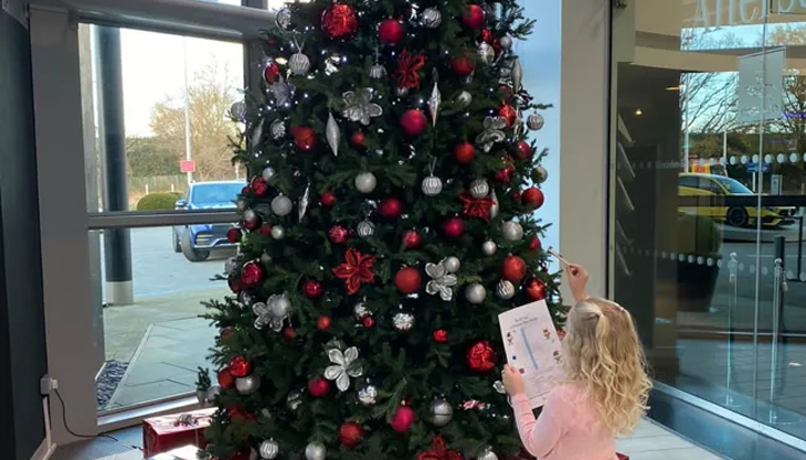 Child At Mercedes Benz World Weybridge At The CHristmas Tree Taking Part In The Christmas Elf Trail