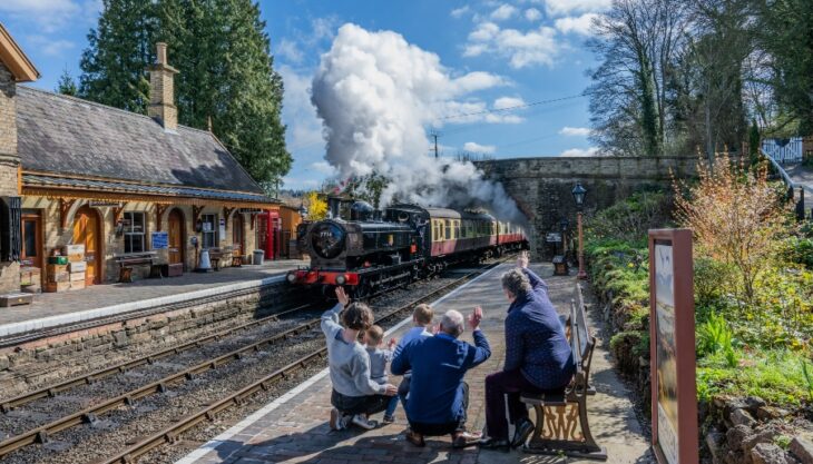 Family Waving At A Steam Train Arriving At Severn Valley Railway